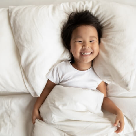 Smiling child laying in bed